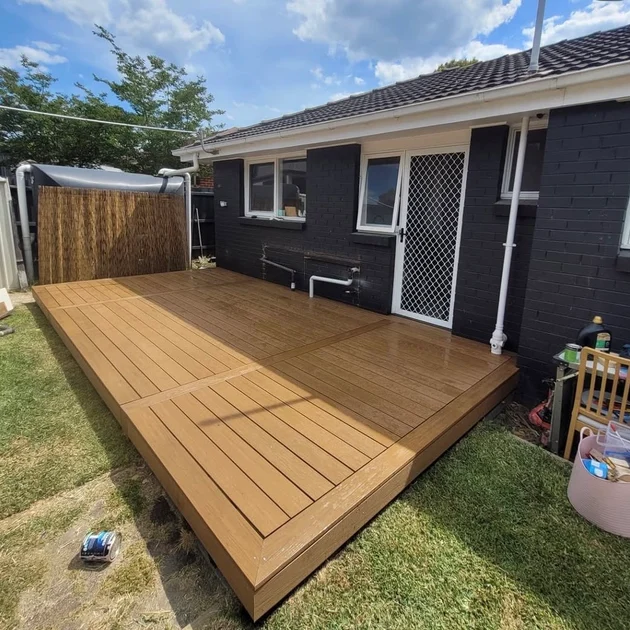 Finished timber deck beside a rendered brick home