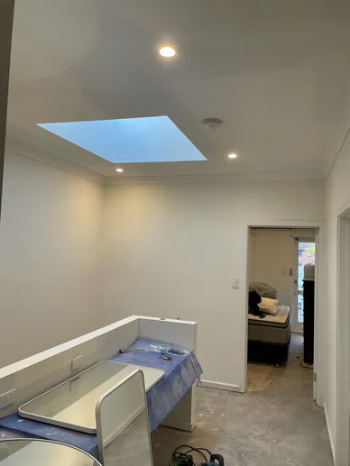 Kitchen and living area mid-renovation with a new skylight