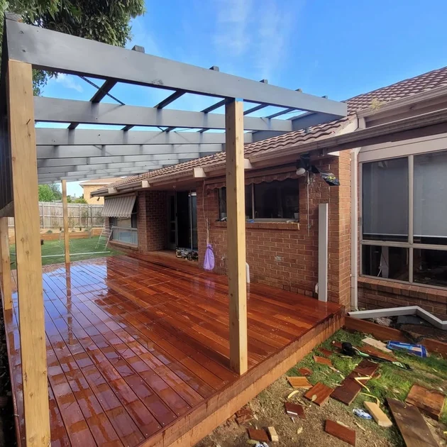 Finished pergola over a timber deck beside a brick home